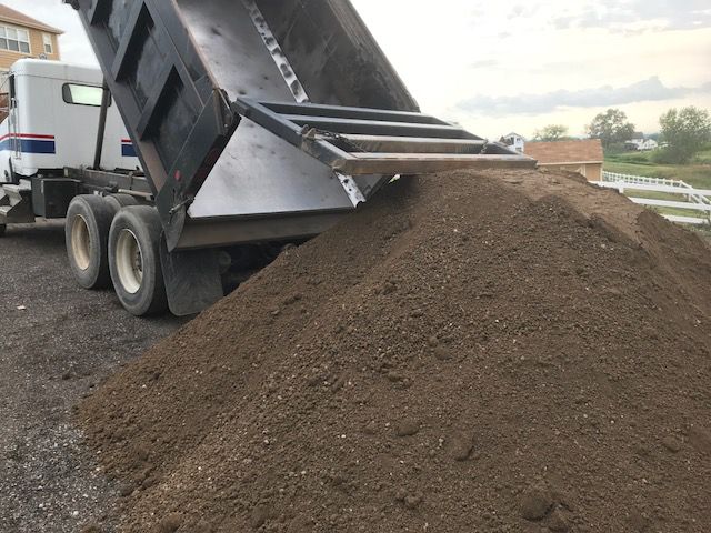 a photo of a truck dumping screened fill dirt.