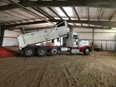 a photo of a dump truck inside of a horse arena