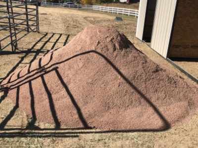a photo of a pile of crusher fines with a shadow of a fence laying on top.
